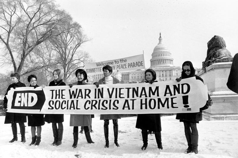 Members of a women’s brigade hold a banner protesting the Vietnam War at a march led by former Montana congresswoman Jeannette Rankin in Washington, D.C. on Jan. 15, 1968. Behind them are other protesters and the U.S. Capitol building. Carrying the sign, from left, are: Ruth Krause, Mrs. Vel Phillips, Wenn Griffin, Ruth Warwick, and Lucy Montgomery. Photo via AP Images.